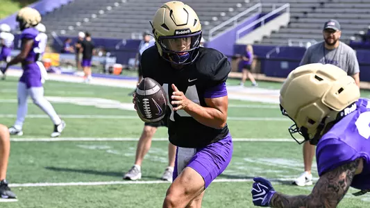 Tanner Vibabul makes a handoff during a JMU football practice