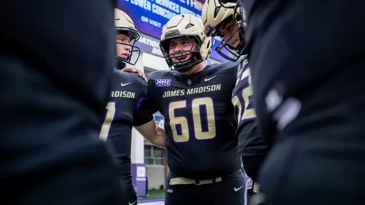 Zach Greenberg talks with teammates during a pregame huddle prior to JMU's game against Wagner on Sept. 12.