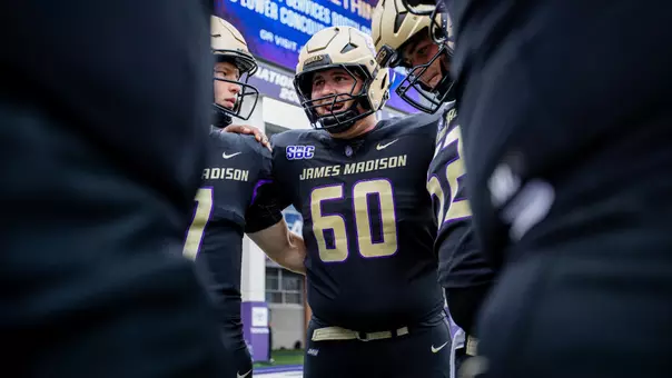 Zach Greenberg talks with teammates during a pregame huddle prior to JMU's game against Wagner on Sept. 12.