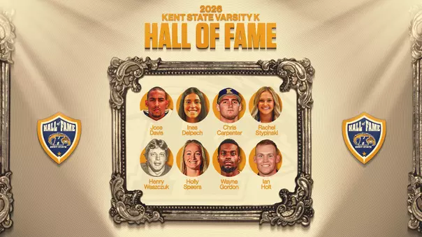 Graphic announcing the 2026 Kent State Varsity K Hall of Fame class. An ornate antique silver frame at center holds eight circular headshots in two rows of four, each with the honoree’s name beneath: Jose Davis, Ines Delpech, Chris Carpenter, Rachel Stypinski, Henry Waszczuk, Holly Speers, Wayne Gordon and Ian Holt. Waszczuk’s photo is black and white. Carpenter wears a navy Kent State baseball cap. “2026 Kent State Varsity K Hall of Fame” appears in gold lettering above the frame, and a navy and gold Kent State Hall of Fame shield logo sits on each side, all against a cream and tan draped-fabric background.