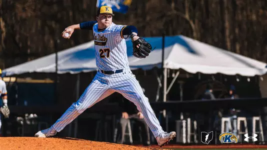 A baseball player (Rocco Bernadina) from Kent State is pitching on a field. The player is wearing a striped uniform and a hat with a "K." Logos for Kent State and Under Armour are visible at the bottom.