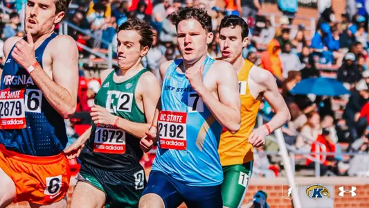 Kent State track and field athlete Preston Rieger, wearing bib number 2192, competes in a crowded field at the Raleigh Relays, running alongside athletes from Virginia, Eastern Michigan, and other programs in front of a packed stadium.