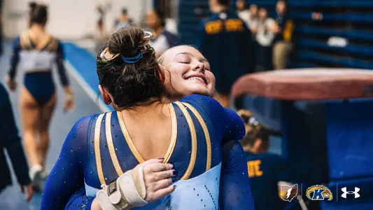 Taylor Archambeau hugging teammate at meet