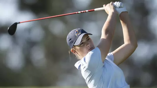 Kent State junior Veronika Kedronová at the top of her backswing with a driver during the first round of the Augusta National Women's Amateur at Champions Retreat Golf Club, wearing a light blue Kent State polo and navy cap with the Golden Flashes logo.