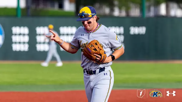 Ripken Reese from Kent State is on the field, wearing a gray uniform with a yellow and blue cap, holding a glove, and gesturing with one hand.
