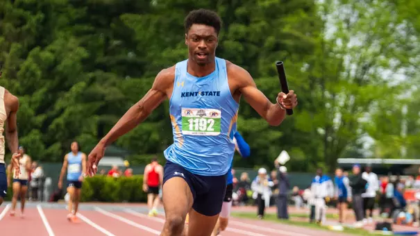 Kent State sprinter Jacob Stanley (bib 1192) drives down the track while carrying the relay baton during the MAC Outdoor Track and Field Championships.