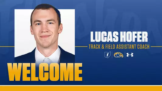 A Kent State Athletics welcome graphic on a royal blue background announcing Lucas Hofer as Track & Field Assistant Coach.A Kent State Athletics welcome graphic on a royal blue background announcing Lucas Hofer as Track & Field Assistant Coach. A headshot of Hofer — a young man in a navy blazer and white dress shirt — appears on the left alongside the word "WELCOME" in large gold letters. On the right, his name appears in bold white text above his title in gold, with the Ohio outline logo, Kent State Golden Flashes logo, and Under Armour logo displayed below.