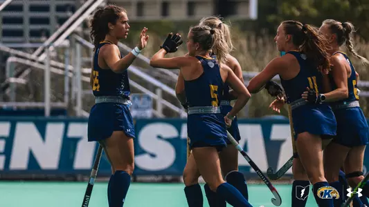 Field Hockey team huddling around center field