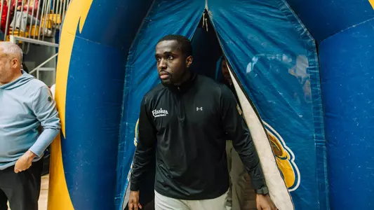 Kent State Men's Basketball Assistant Coach Jalen Avery walks through the inflatable Golden Flashes entrance tunnel onto the court before the game against Miami.