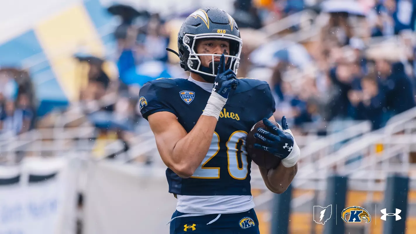 Kent State Golden Flashes college football player wearing jersey number 20 and a dark blue helmet featuring gold lightning bolt decals and a MAC conference logo on the jersey.