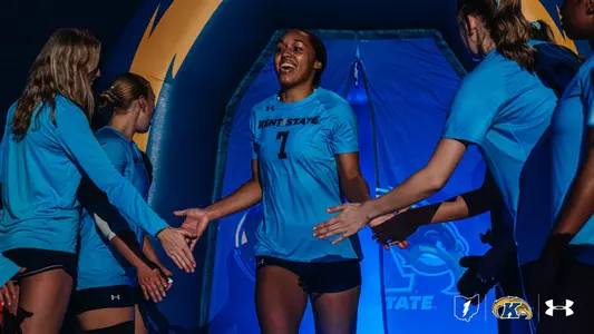Kent State volleyball player No. 7 smiles and high-fives teammates as she runs through the player tunnel during pregame introductions.