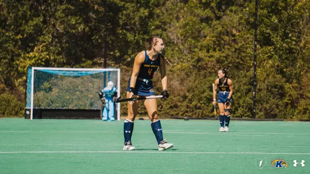Riley Welsch and Lauren Conroy backpeddaling in a game. Michaela Skinner looks on in the distance from inside the goal