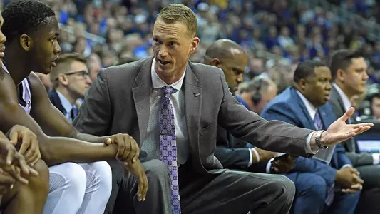 Brad Korn converses with Montavious Murphy on the bench during a game.