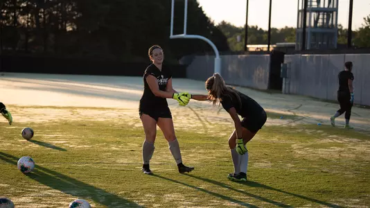 Alaina Werremeyer helps up Cameron Illingworth at practice