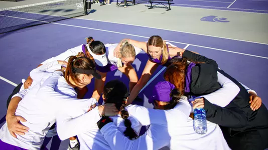 Tennis team in huddle in match against Iowa State on March 1 at Mike Goss Tennis Stadium