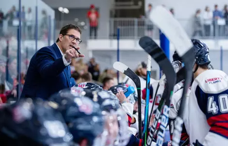 Jeff Boettger behind DI men's hockey bench