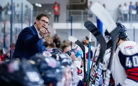 Jeff Boettger coaches behind the DI men's hockey bench