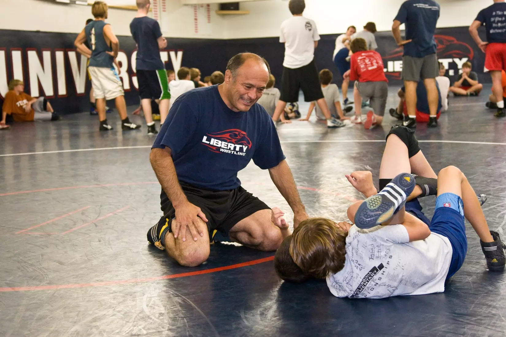 Liberty wrestling coach Jesse Castro instructs camp participants. volleyball