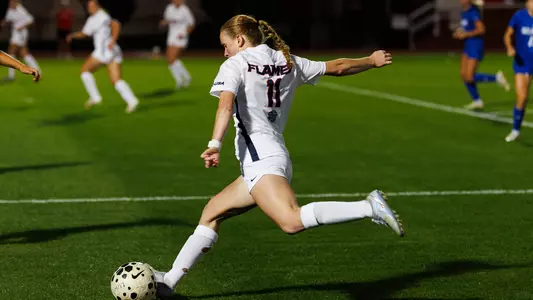 Women's Soccer Avery Paulson kicks the ball while running in a game at Osborne Stadium
