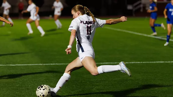 Women's Soccer Avery Paulson kicks the ball while running in a game at Osborne Stadium