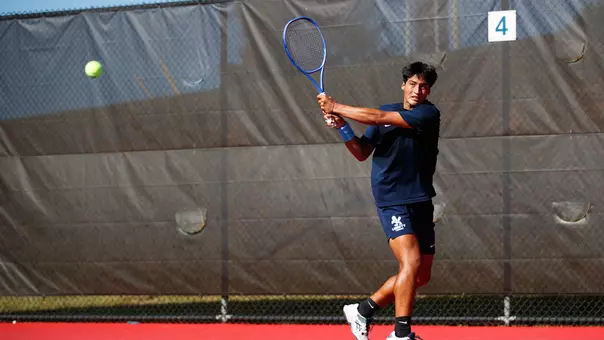 Men's Tennis Angel Veliz hits a backhand at the Liberty Tennis Complex