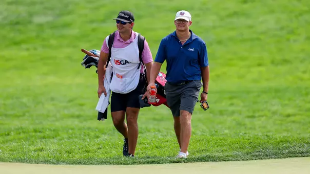 Liberty men's golfer Michael Lugiano and his caddie Bobby Lugiano walk to the fourth hole green during the round of 16 of the 2026 U.S. Amateur at Merion Golf Club in Ardmore, Pa. on Thursday, Aug. 13, 2026. (Ishika Samant/USGA)