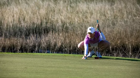 Women's golfer lining up putt