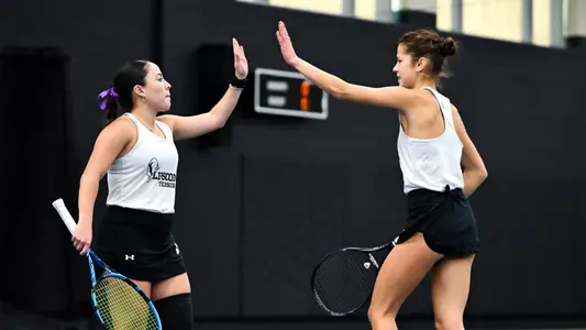 Deborah Dominguez Collado and Sofiia Zhylchuk giving a high-five after a doubles game.