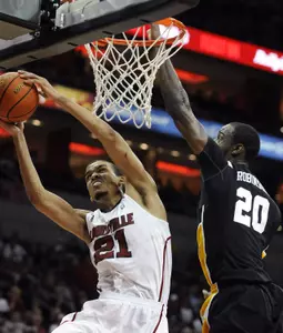 Louisville's Jared Swopshire, left, attempts a shot around the defense of Long Beach State's T.J. Robinson during the first half of their NCAA college basketball game, Monday, Nov. 28, 2011, in Louisville, Ky. Louisville defeated Long Beach State 79-66. (AP Photo/Timothy D. Easley)