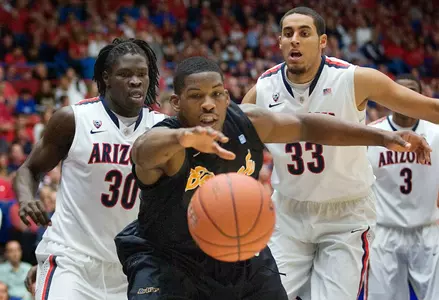 Long Beach State's Dan Jennings, center, reaches for the ball in front of Arizona's Angelo Chol (30) and Grant Jerrett (33) during the first half of an NCAA college basketball game in Tucson, Ariz., Monday, Nov. 19, 2012. (AP Photo/Wily Low)