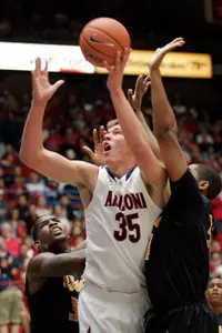 Arizona's Kaleb Tarczewski (35) is sandwiched between Long Beach State's Keala King, left, and Dan Jennings, right, as he shoots during the first half of an NCAA college basketball game in Tucson, Ariz., Monday, Nov. 19, 2012. (AP Photo/John Miller)