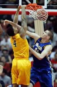Long Beach State forward Eugene Phelps (4) dunks the ball, despite getting an arm to the face from UC Santa Barbara center Greg Somogyi (55), during the first half of an NCAA college basketball game in the championship of their Big West Conference tournament, Saturday, March 10, 2012, in Anaheim, Calif.  (AP Photo/Alex Gallardo)