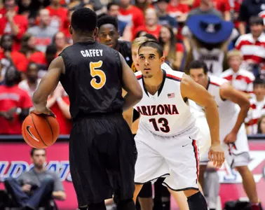 Nov 11, 2013; Tucson, AZ, USA; Arizona Wildcats guard Nick Johnson (13) defends Long Beach State 49ers guard Mike Caffey (5) during the second half at McKale Center. Arizona beat Long Beach State 91-57. Mandatory Credit: Casey Sapio-USA TODAY Sports