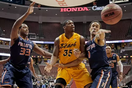 Long Beach State forward Dan Jennings (35) has the ball stolen by Cal State Fullerton guard Jared Brandon (1) as guard Chris Collins (33) defends in the first half of an NCAA college basketball game in the Big West Conference tournament Thursday, March 14, 2013, in Anaheim, Calif. Long Beach State won 75-66. (AP Photo/Reed Saxon)