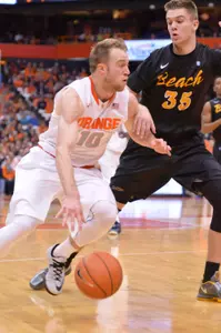 Dec 28, 2014; Syracuse, NY, USA; Syracuse Orange guard Trevor Cooney (10) drives the ball past Long Beach State 49ers forward Jack Williams (35)  during the first half of a game at the Carrier Dome. Mandatory Credit: Mark Konezny-USA TODAY Sports