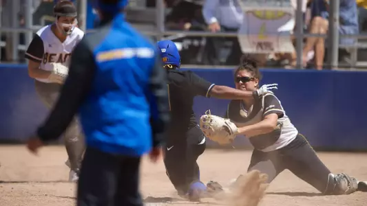 Karli Sandoval applies the tag to end the seventh inning at the plate.