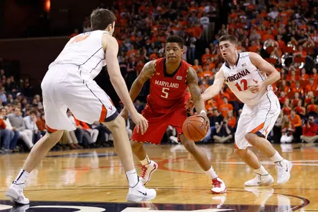 Feb 10, 2014; Charlottesville, VA, USA; Maryland Terrapins guard Nick Faust (5) dribbles the ball as Virginia Cavaliers forward/center Mike Tobey (10) and Cavaliers guard Joe Harris (12) defend in the first half at John Paul Jones Arena. The Cavaliers won 61-53. Mandatory Credit: Geoff Burke-USA TODAY Sports