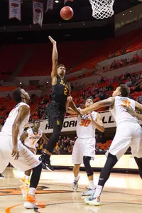 Long Beach State 49ers guard Nick Faust (2) shoots the ball as Oklahoma State Cowboys guard Jeffrey Carroll (30) defends during the first half at Gallagher-Iba Arena.