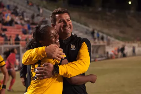Head coach Mauricio Ingrassia and freshman Fatmata Kamara celebrate after defeating UC Riverside 1-0, in overtime in a Big West Tournament semifinal game at Titan Stadium. (Photo by John Fajardo/LBSU)