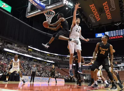 Mar 10, 2017; Anaheim, CA, USA; Long Beach State 49ers guard Barry Ogalue (13) shoots past UC Irvine Anteaters center Ioannis Dimakopoulos (12). Robert Hanashiro-USA TODAY Sports