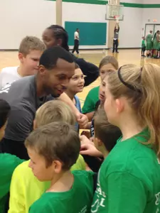 Junior guard Chris Campbell brings the group together after leading the kids in passing and shooting drills at the annual North Texas Youth Basketball Clinic.