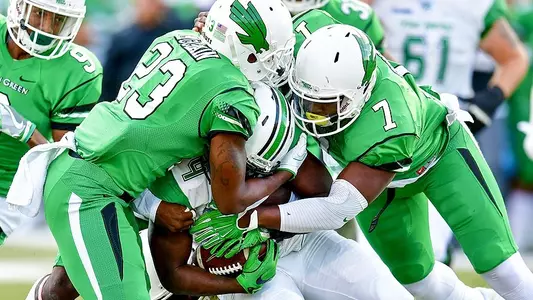 North Texas defenders Kishawn McClain and Jareid Combs swarm a Marshall ball carrier Saturday night.