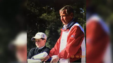 Golfer (Sean Wilcox) as a child standing with another golfer on a golf course