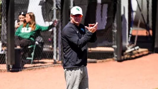 Cody White coaches third base against Charlotte on March 28