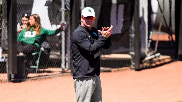 Cody White coaches third base against Charlotte on March 28