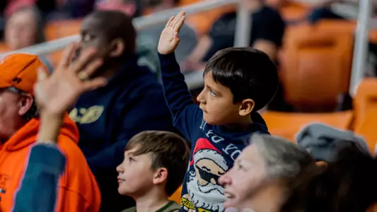 kid raising his hand in the crowd
