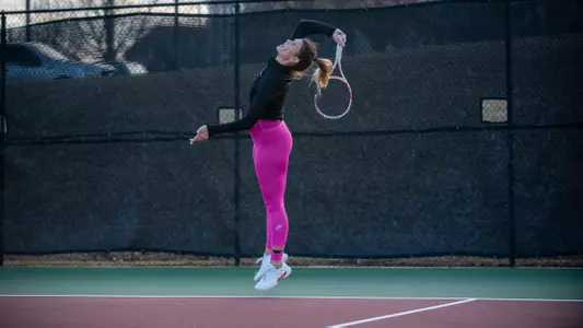 Kristin Yordanova in the middle of her serve with the racket behind her head about to hit the tennis ball