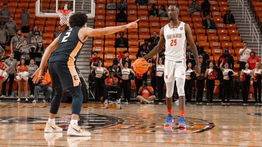 Shawn Walker Jr. walking up the court dribbling the ball while a defender guards him