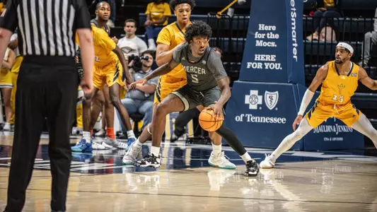 Jalyn McCreary dribbling trying to get around a defender to the basket