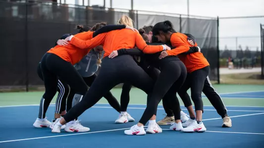 The women's tennis team in a huddle